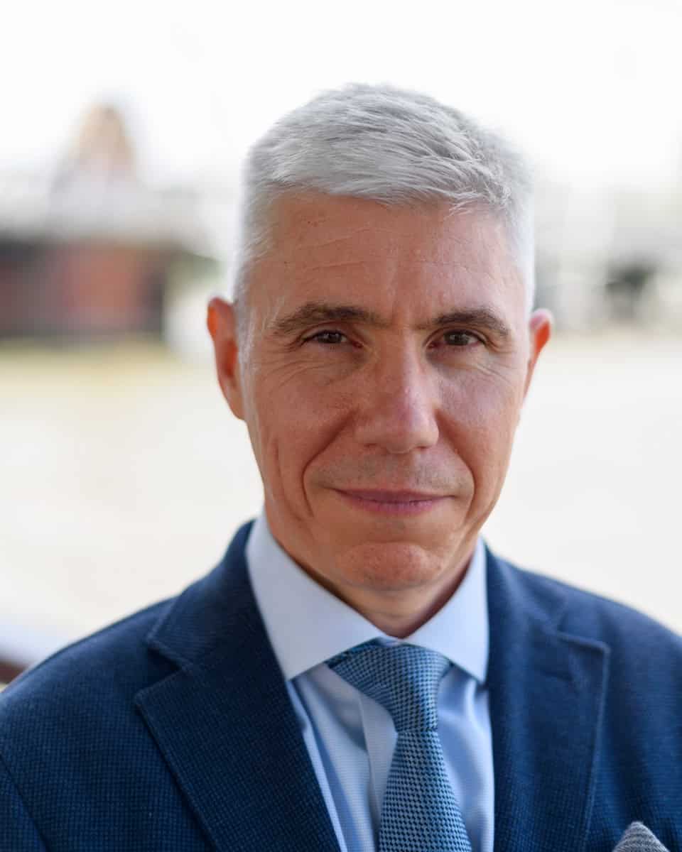 a corporate headshot photo of a male business owner on the Southbank in London. He has white hair and a blue suit and is looking directly into the camera. Photo by Molly Rhianon photography